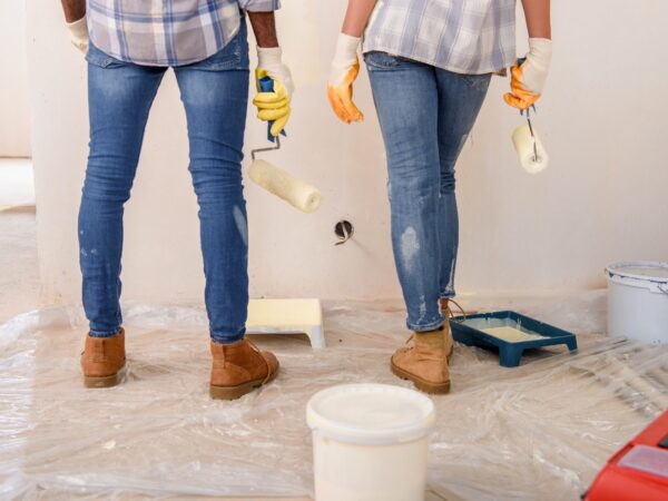 cropped-image-of-couple-with-paint-rollers-standing-near-painted-wall-at-new-home.jpg