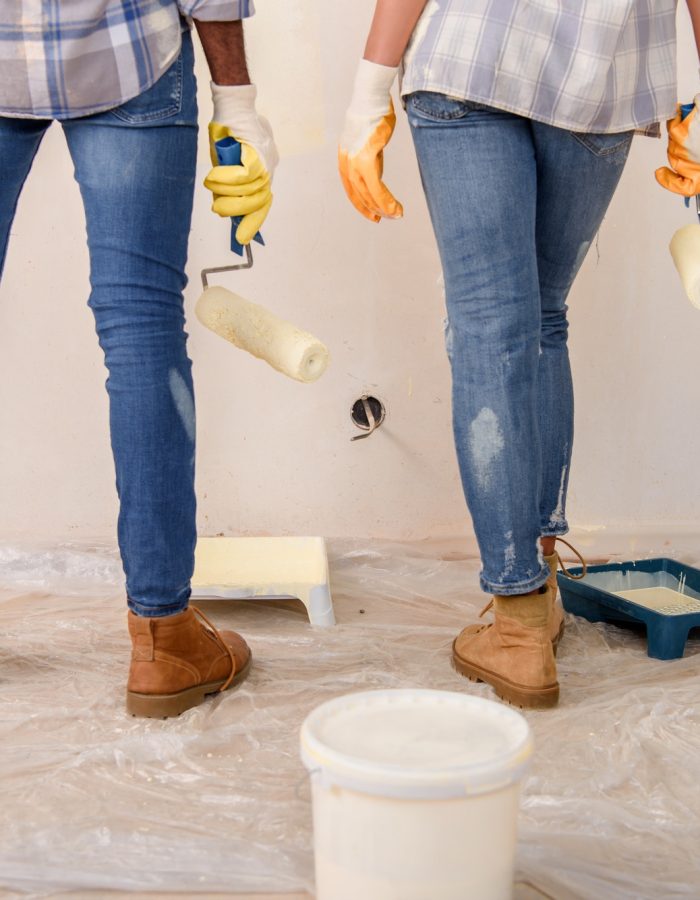 cropped-image-of-couple-with-paint-rollers-standing-near-painted-wall-at-new-home.jpg
